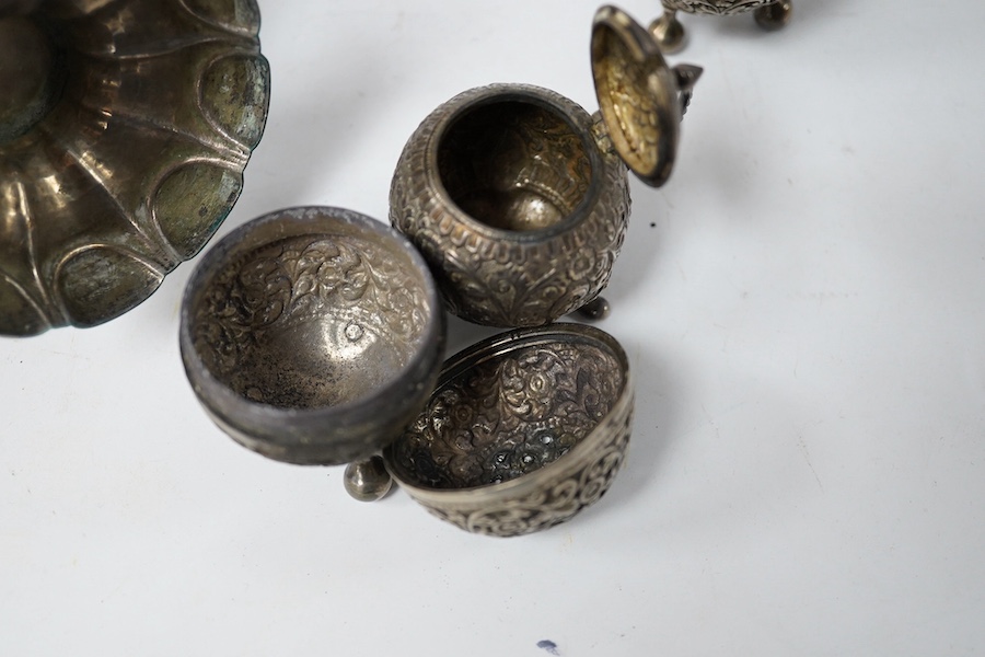 An Indian white metal three piece condiment set, a continental white metal jug, height 14cm, a silver egg cup and an engraved white metal hinged bangle. Condition - poor to fair